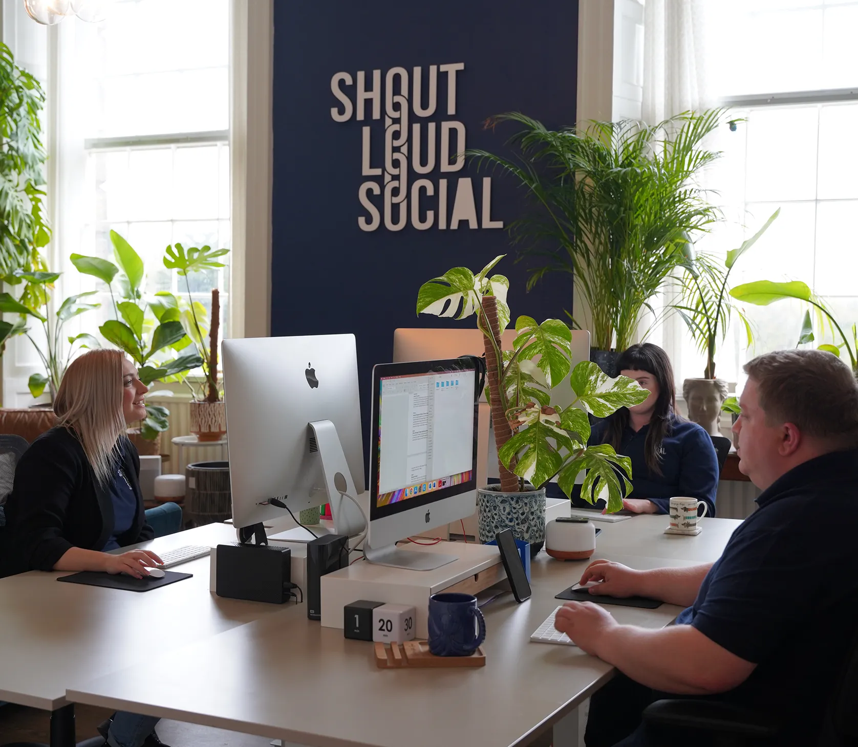 The shout loud social team working at their desks.